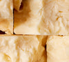 Stacked blocks of crumbly sharp cheddar. 